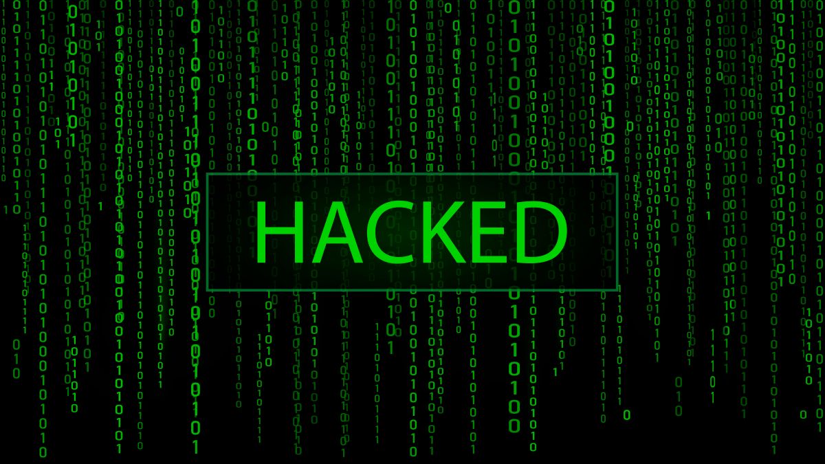 Green matrix style binary computer code cascading down a dark background with the word HACKED glowing in the center. The digital display represents a cyber attack and compromised system security in a high tech environment.