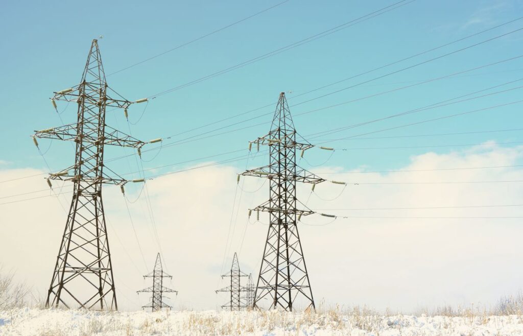 Towers of power lines in the winter field Electrical equipment