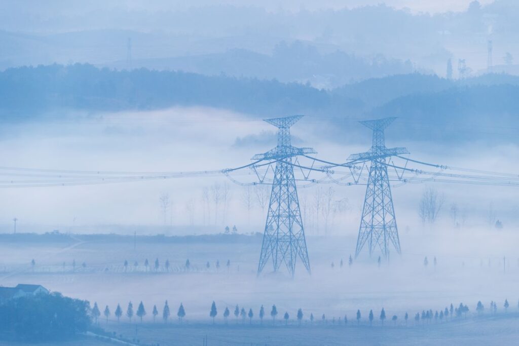 power transmission towers in the morning fog