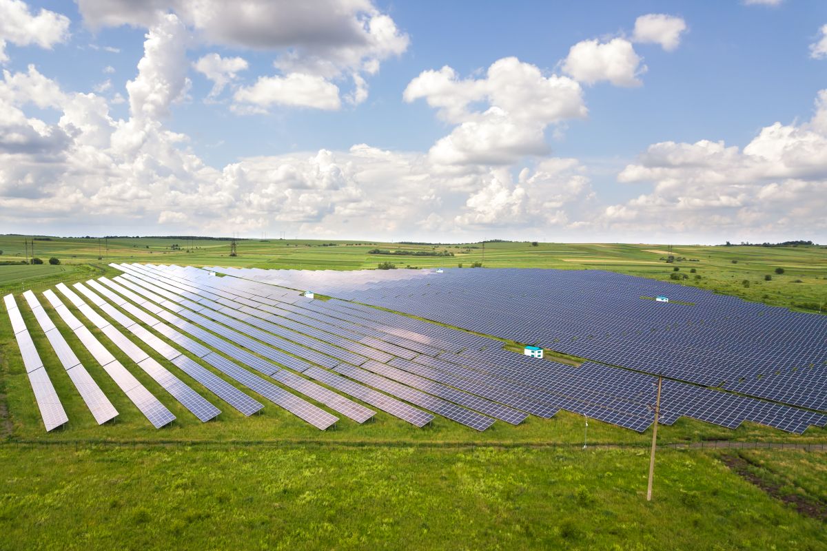 Aerial view of solar power plant on green field Electric panels for producing clean ecologic energy Aerial view of solar power plants on green field Electric panels for producing clean ecologic energy
