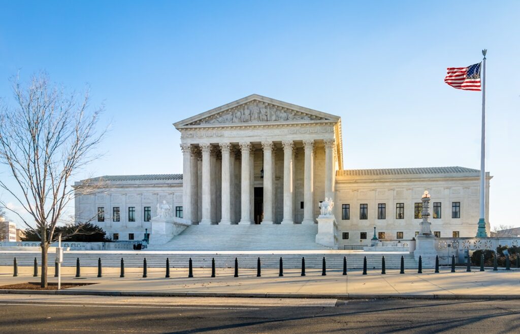U.S. Supreme Court building with the American flag, related to the Solicitor General’s request to reject Duke Energy's antitrust appeal.
