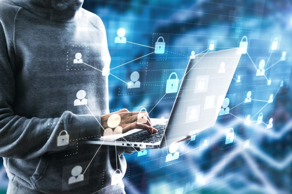 Person working on a laptop with a digital cybersecurity network visual, representing key elements required for CIP-015-1 compliance.