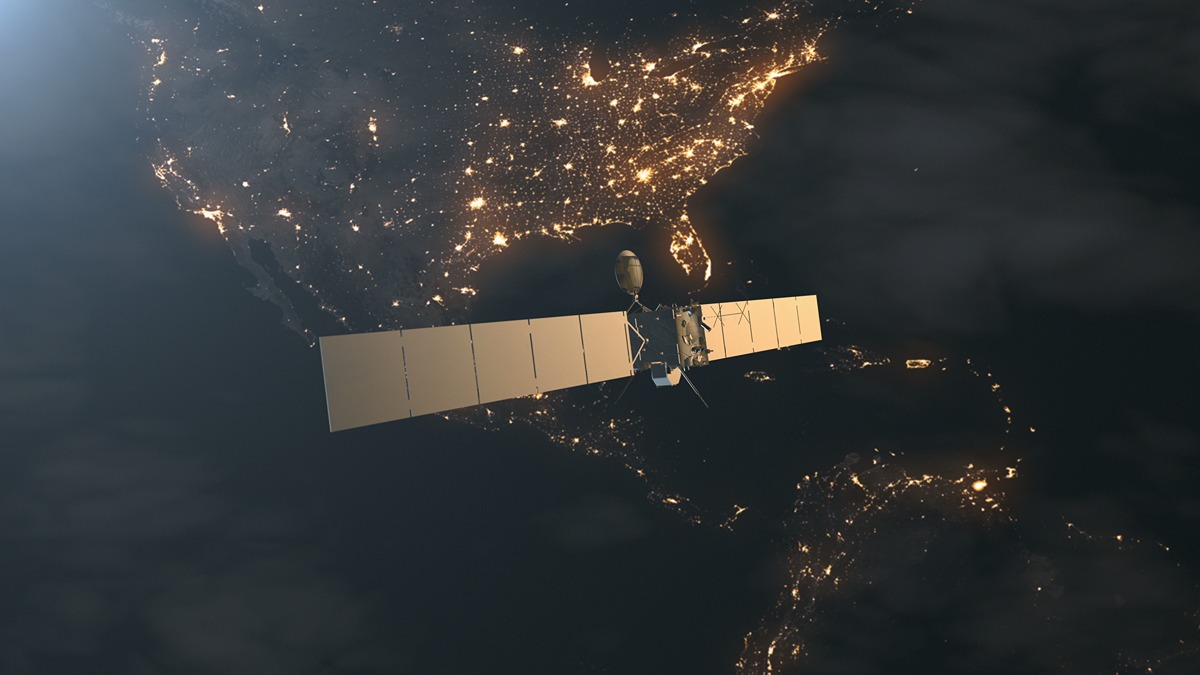 Satellite orbiting above the illuminated eastern United States at night, capturing data over densely lit cities and infrastructure. The image highlights space-based monitoring capabilities used to assess dam stability and detect potential risks.