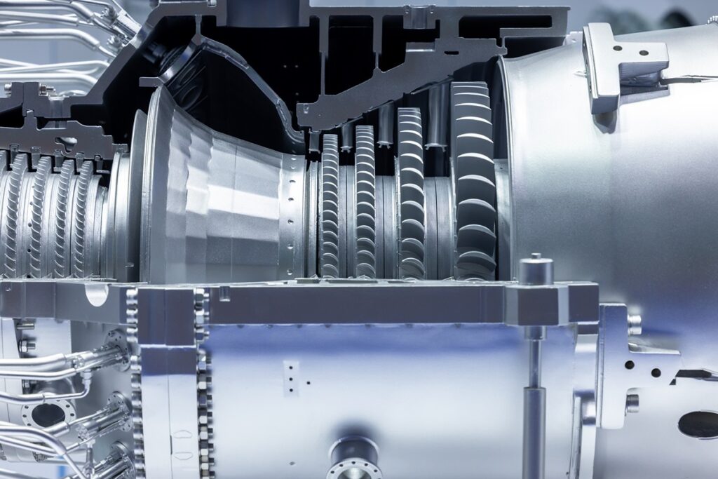 Close-up view of the interior of a high-tech gas turbine, revealing metallic blades, rotors, and precision-engineered components. The image highlights advanced manufacturing and energy infrastructure, aligning with Siemens Energy’s investment in U.S. gas turbine production.