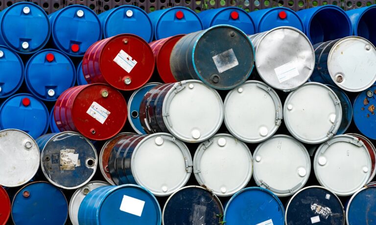 Commercial Crude Oil Inventories Increased by 20 Million Barrels-Certrec Stack of metal oil drums in blue, red, and gray colors piled in a storage yard.
